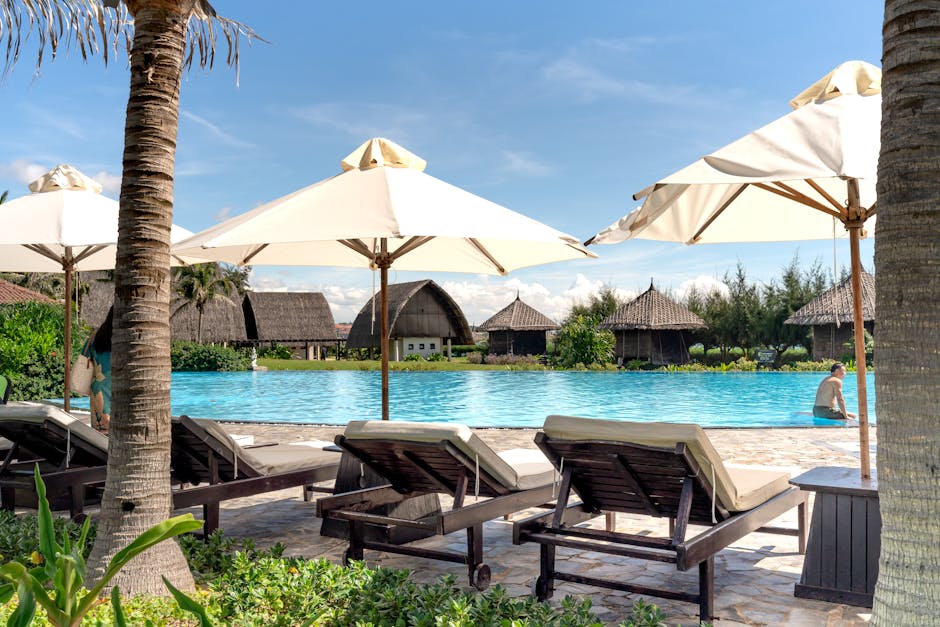 Relax by the pool with luxury resort amenities under sunny skies.
