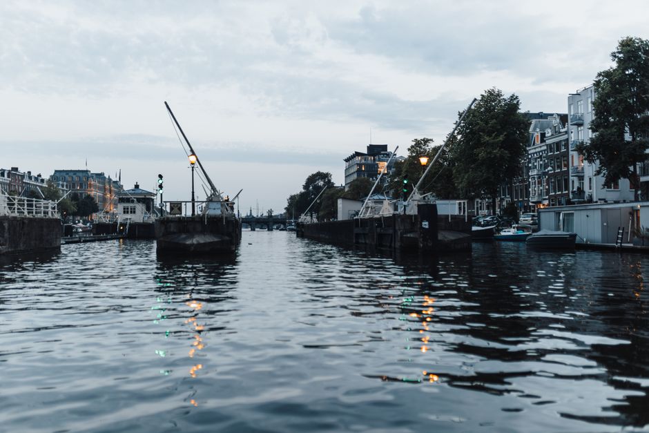 A serene evening view of Amsterdam's iconic canal with elegant waterfront buildings.