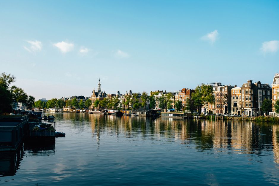 Beautiful view of Amsterdam's iconic canal and historic buildings on a sunny day.