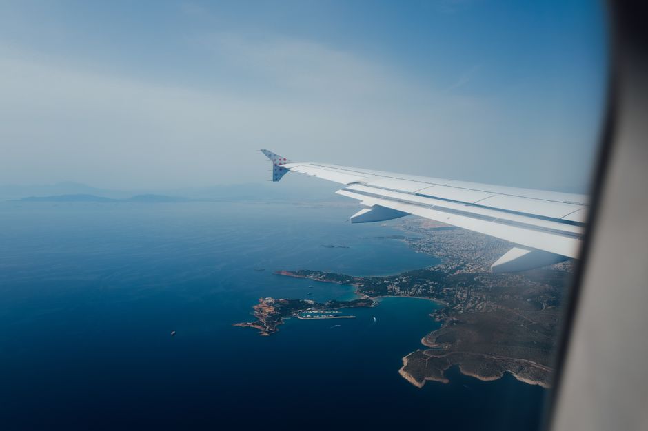 Scenic aerial view from airplane window showcasing coastline and sea, perfect for travel content.