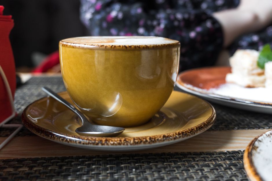 A warm cappuccino in a ceramic cup on a cozy cafe table.