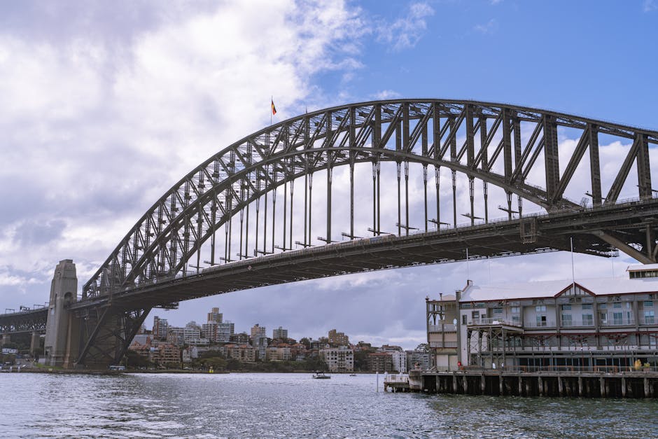 Iconic view of the Sydney Harbour Bridge with city skyline in the background. Vibrant urban scene.