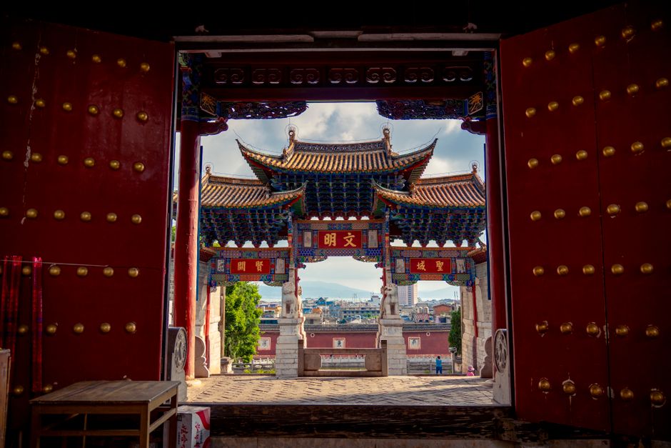 Captivating view through a traditional Chinese temple gate with vibrant architectural details.